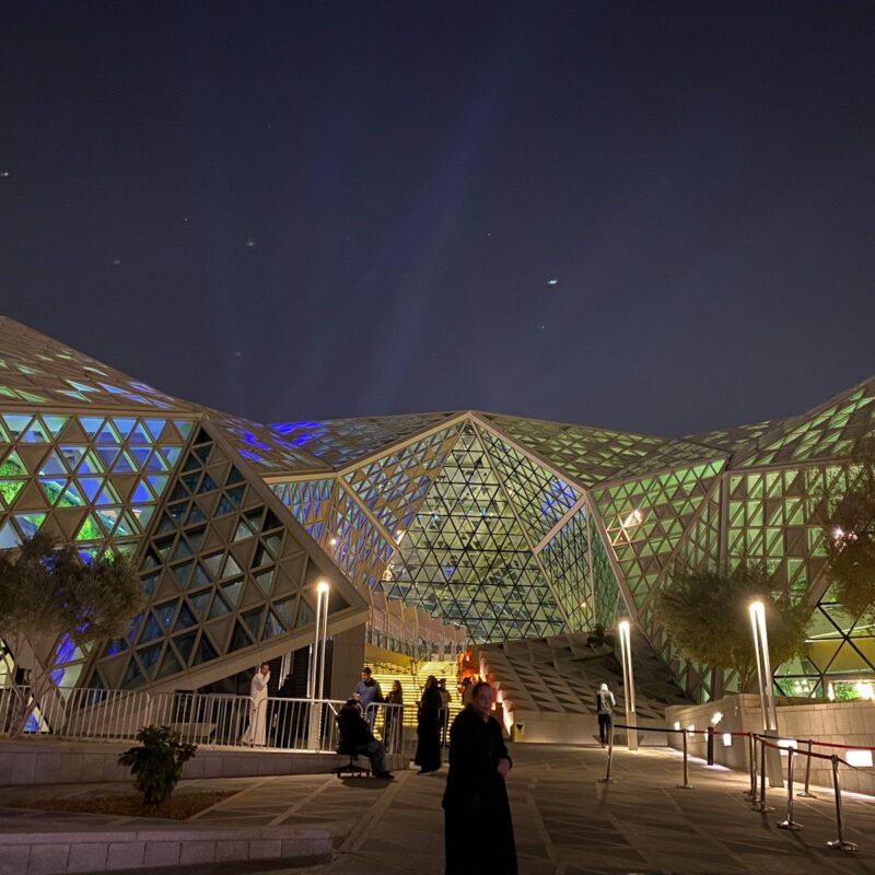 a group of people standing outside of a building at night